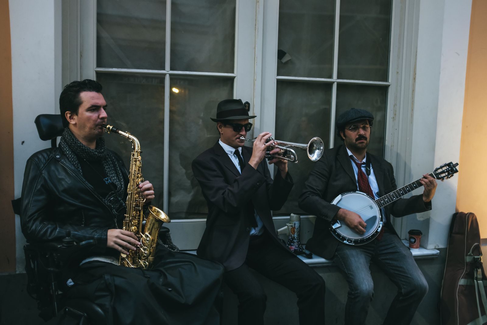 Three musicians playing saxophone, trumpet and banjo in a traditional jazz trio